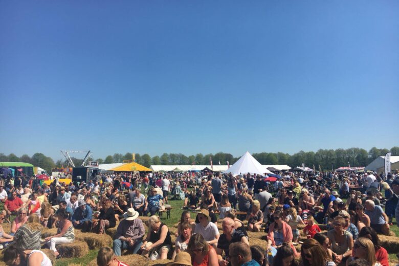 Crowd of people sat eating and drinking in blazing sunshine at the Great Northern Food Festival